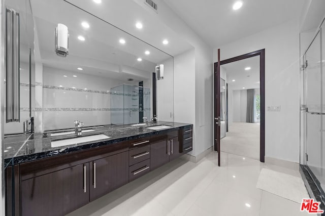 bathroom with vanity, tile patterned floors, and a shower with door