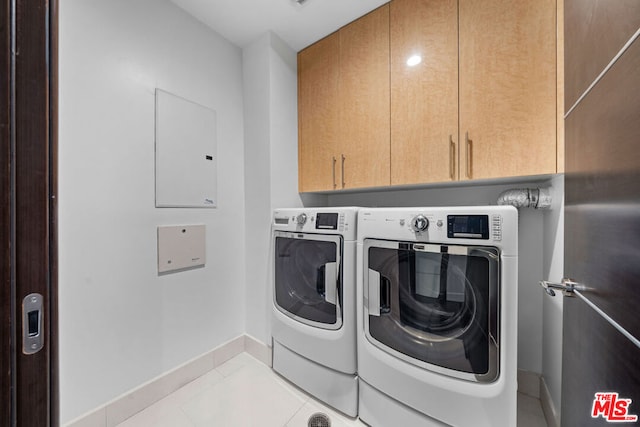 laundry area with cabinets, independent washer and dryer, and light tile patterned flooring