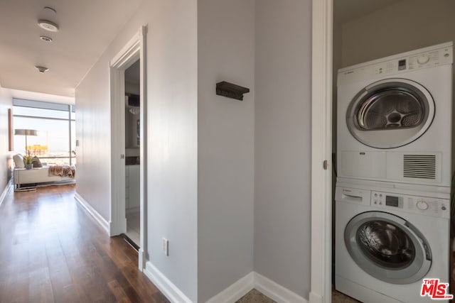 clothes washing area with stacked washer / dryer and dark hardwood / wood-style flooring