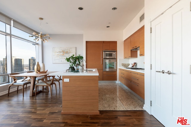 kitchen featuring appliances with stainless steel finishes, dark wood-type flooring, sink, extractor fan, and a notable chandelier