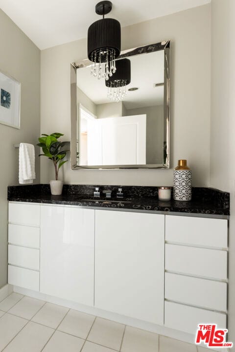 bathroom featuring vanity, an inviting chandelier, and tile patterned flooring