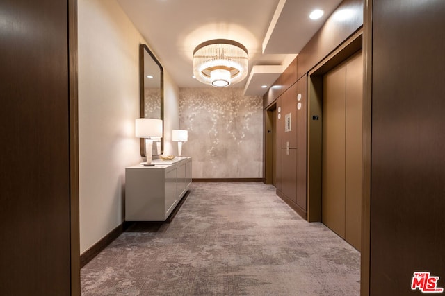 hallway with dark colored carpet and elevator