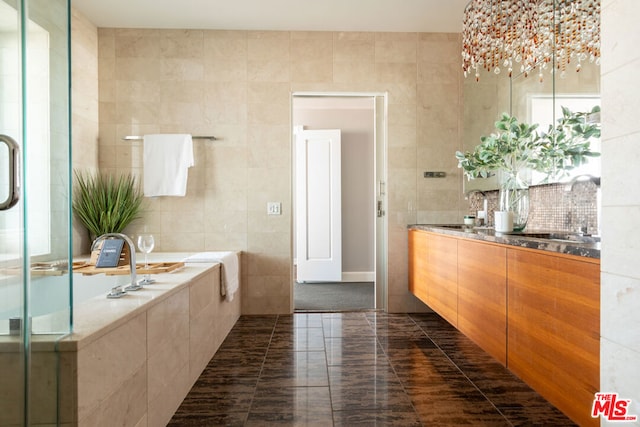 bathroom with plus walk in shower, tile walls, tile patterned flooring, and vanity