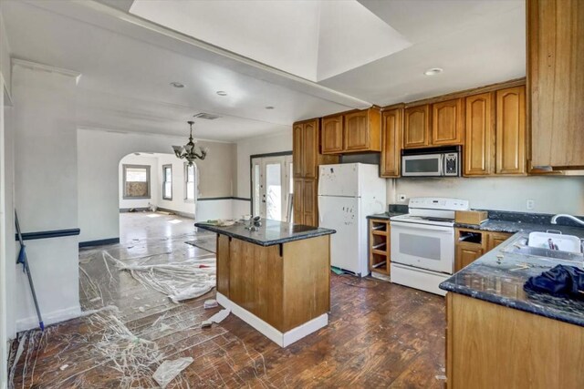 kitchen with white appliances, a center island, plenty of natural light, and sink