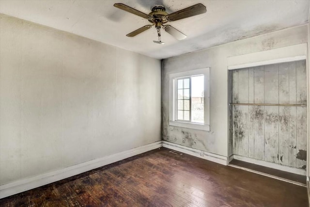 unfurnished room featuring ceiling fan and dark wood-type flooring