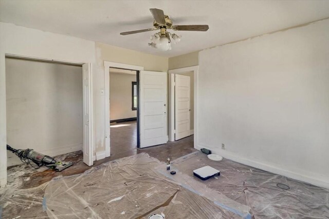 unfurnished bedroom with ceiling fan and a closet