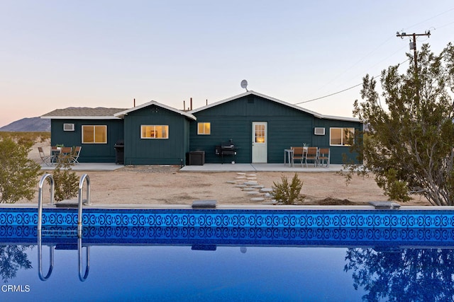 pool at dusk featuring a patio area