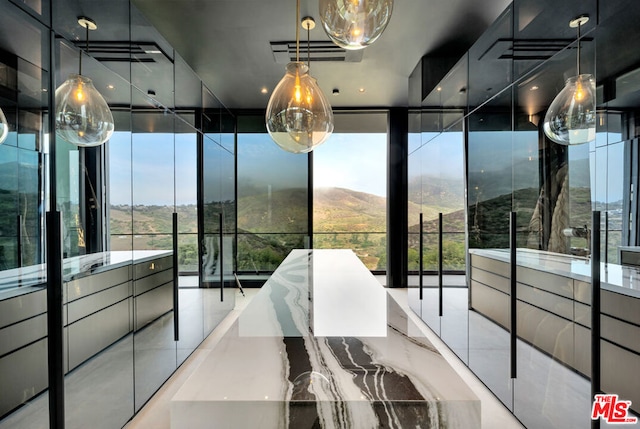 interior space featuring a mountain view and a wall of windows