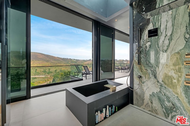 bathroom with floor to ceiling windows and a mountain view