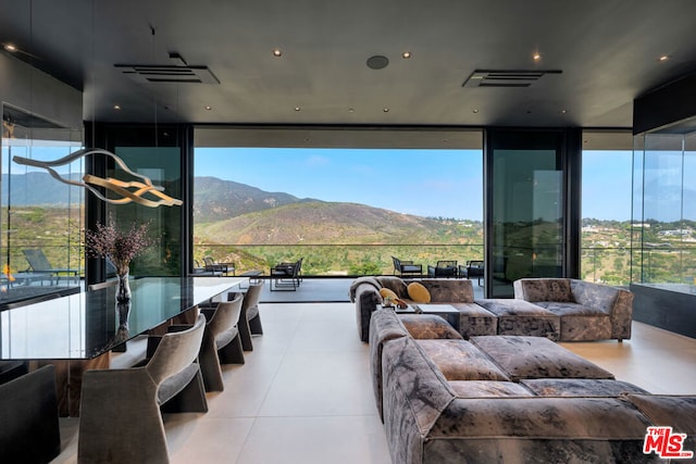 living room featuring a mountain view, expansive windows, and a healthy amount of sunlight