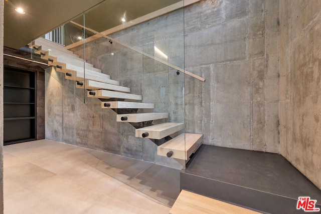 staircase featuring concrete flooring