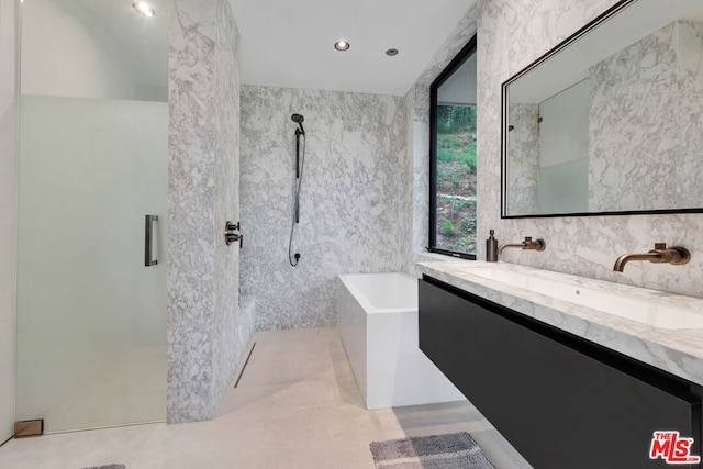 bathroom with vanity, plus walk in shower, and tile walls