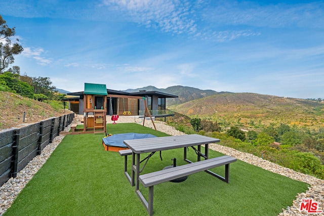 view of community featuring a mountain view and a yard