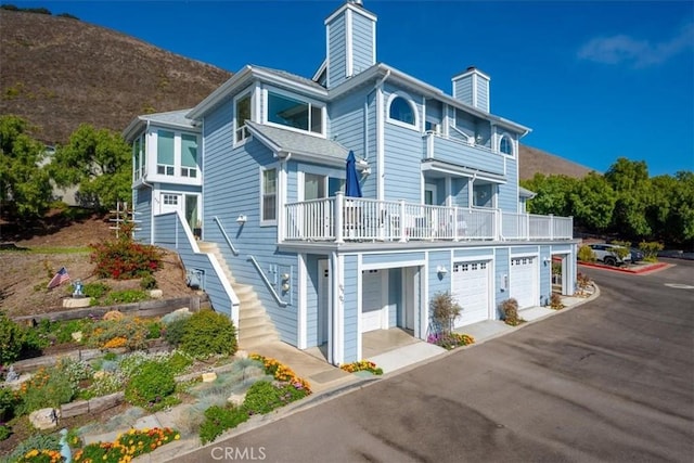 exterior space with a mountain view, a balcony, and a garage