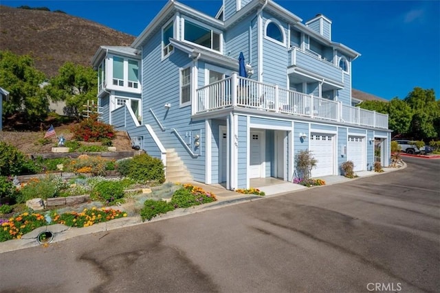 townhome / multi-family property with a mountain view, a garage, and a balcony