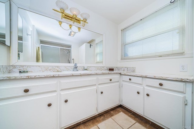 bathroom featuring vanity and a shower with shower door