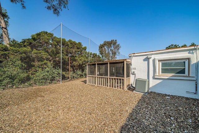 view of yard featuring central air condition unit and a sunroom