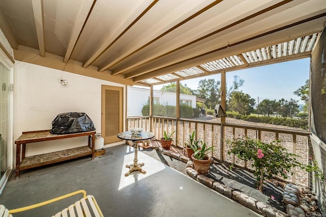 sunroom featuring beam ceiling