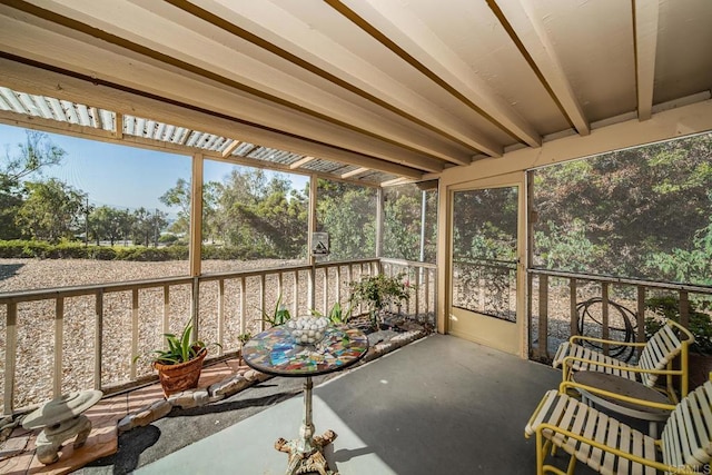 unfurnished sunroom featuring beamed ceiling