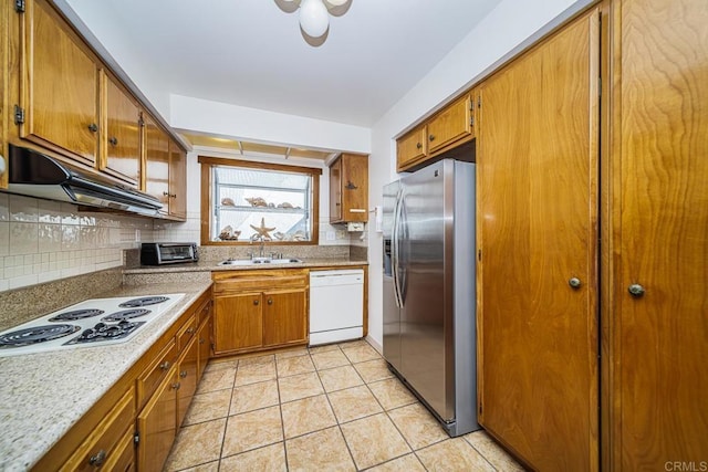 kitchen featuring decorative backsplash, sink, light tile patterned flooring, and white appliances