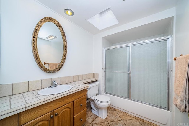 full bathroom with toilet, vanity, tile patterned floors, and bath / shower combo with glass door