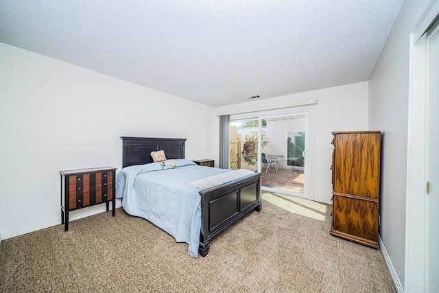 bedroom featuring access to exterior, a textured ceiling, and carpet floors