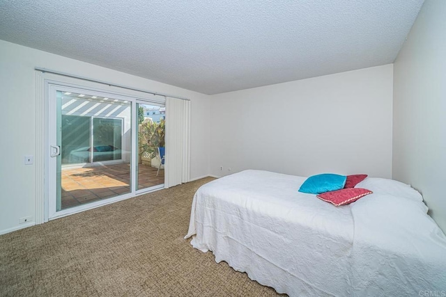 bedroom featuring access to exterior, carpet, and a textured ceiling