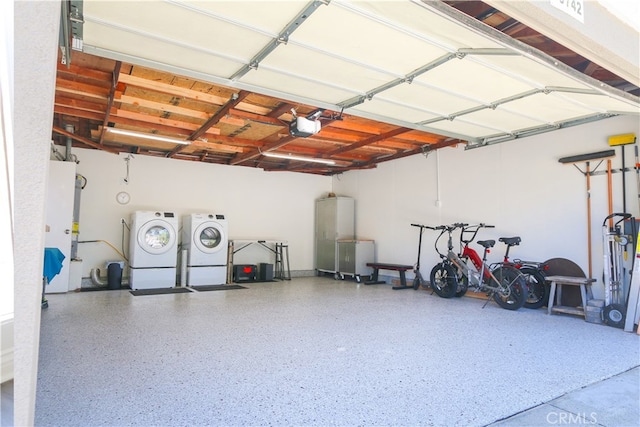 garage with washing machine and clothes dryer and a garage door opener