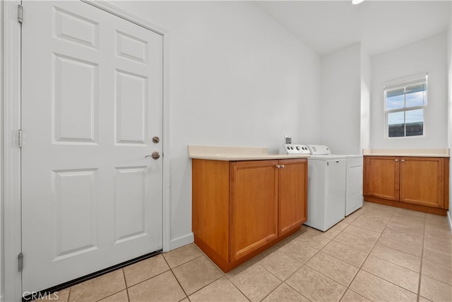 washroom featuring cabinets, light tile patterned floors, and washing machine and clothes dryer