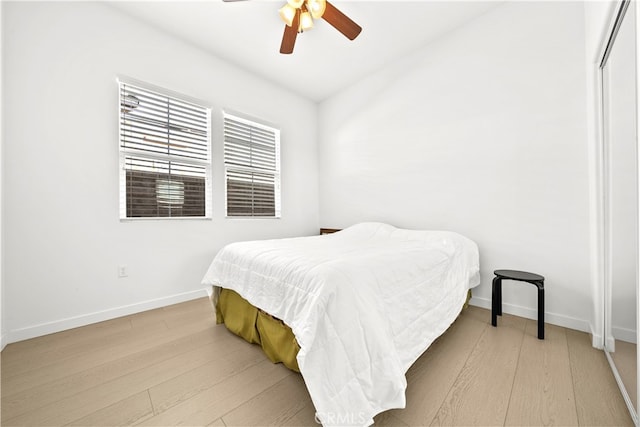 bedroom with light hardwood / wood-style floors, vaulted ceiling, and ceiling fan