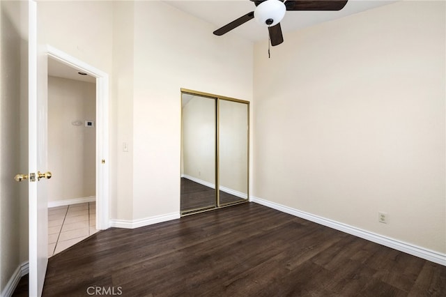 unfurnished bedroom featuring dark wood-type flooring, a closet, and ceiling fan