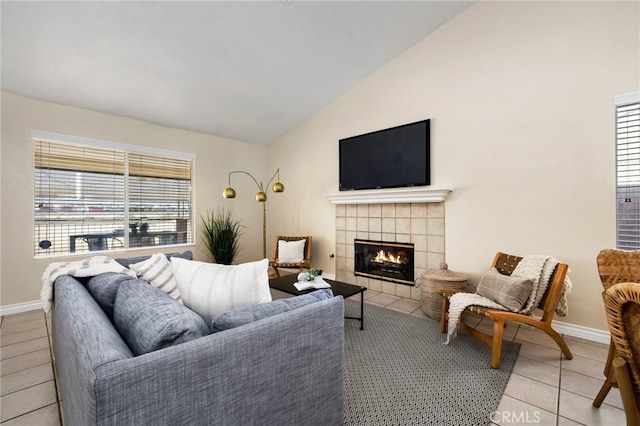 living room featuring light tile patterned flooring, a tile fireplace, and vaulted ceiling