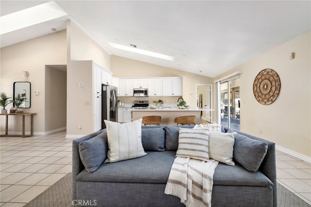 tiled living room with lofted ceiling with skylight