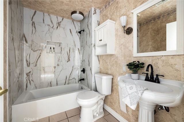 bathroom with toilet, tiled shower / bath, and tile walls