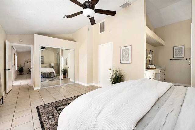 tiled bedroom featuring vaulted ceiling, a closet, and ceiling fan