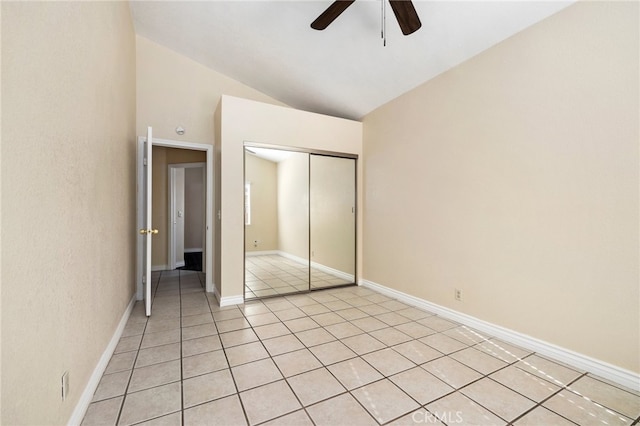 unfurnished bedroom with lofted ceiling, light tile patterned floors, a closet, and ceiling fan