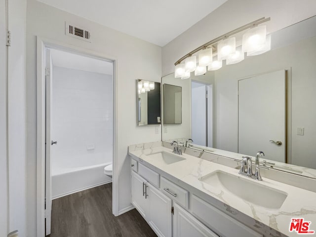 full bathroom with bathing tub / shower combination, hardwood / wood-style flooring, vanity, and toilet