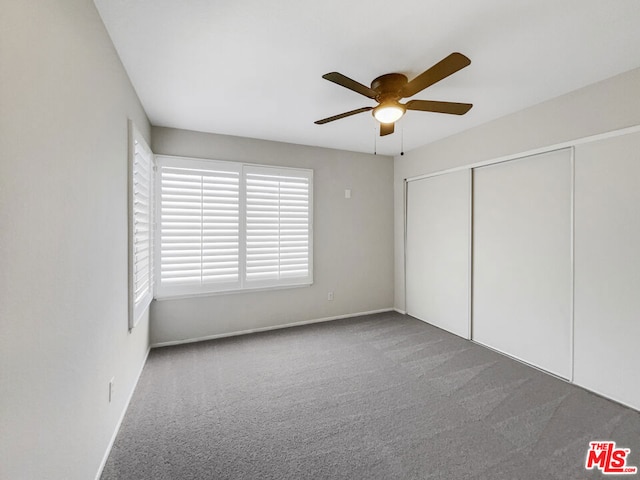 unfurnished bedroom with ceiling fan, a closet, and carpet flooring