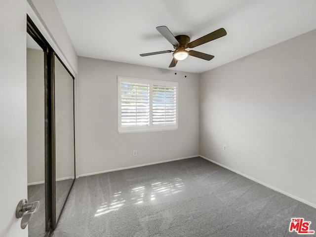 unfurnished bedroom featuring ceiling fan, a closet, and carpet