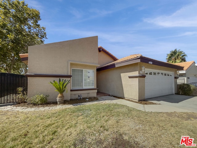 view of front of home with a front yard and a garage