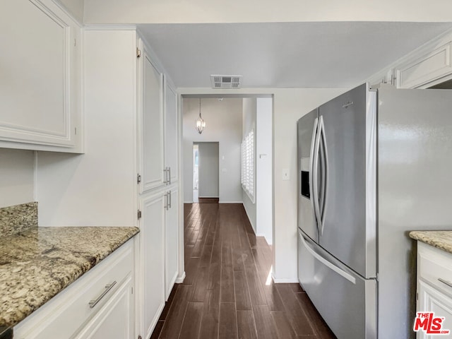 kitchen featuring pendant lighting, light stone counters, dark wood-type flooring, stainless steel fridge with ice dispenser, and white cabinets