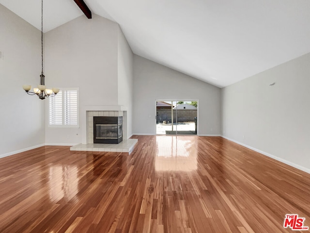 unfurnished living room with high vaulted ceiling, beam ceiling, hardwood / wood-style flooring, and plenty of natural light