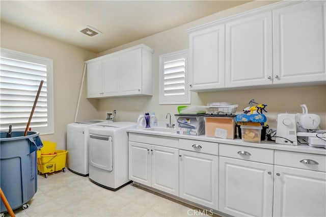 washroom with cabinets, sink, and washing machine and clothes dryer