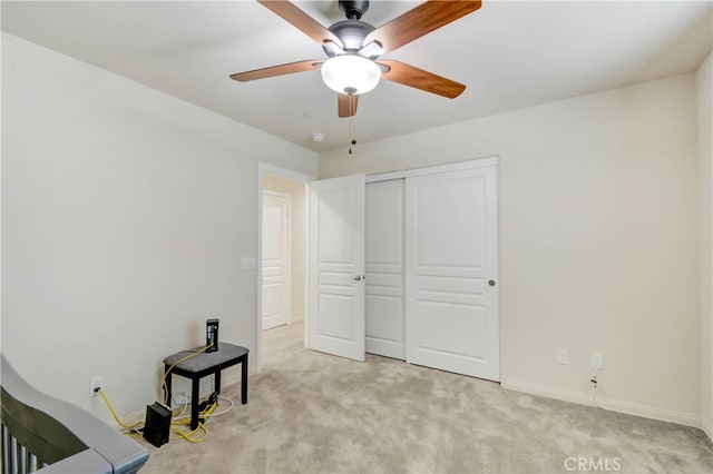 unfurnished bedroom with ceiling fan, light colored carpet, and a closet