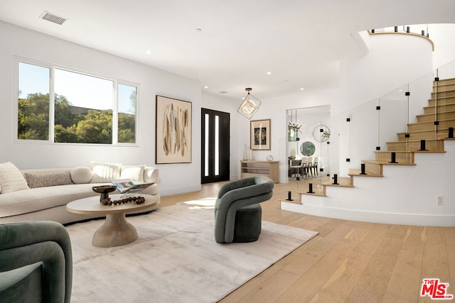 living room with hardwood / wood-style flooring and a notable chandelier