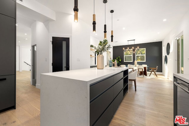 kitchen with decorative light fixtures, an inviting chandelier, light hardwood / wood-style flooring, dishwasher, and a large island