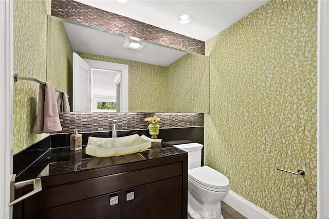 bathroom featuring decorative backsplash, vanity, and toilet