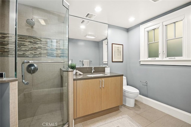 bathroom featuring tile patterned flooring, vanity, toilet, and walk in shower