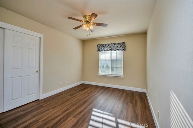 unfurnished bedroom featuring ceiling fan and dark wood-type flooring