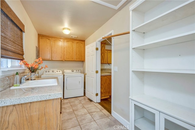 washroom with light tile patterned floors, cabinets, sink, and washer and dryer